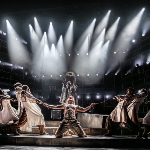 Credit: Johan Persson The full cast of the show during its climax. Judas stands behind a kneeling Jesus holding aloft a crown of thorns he is about to place on Jesus's head.